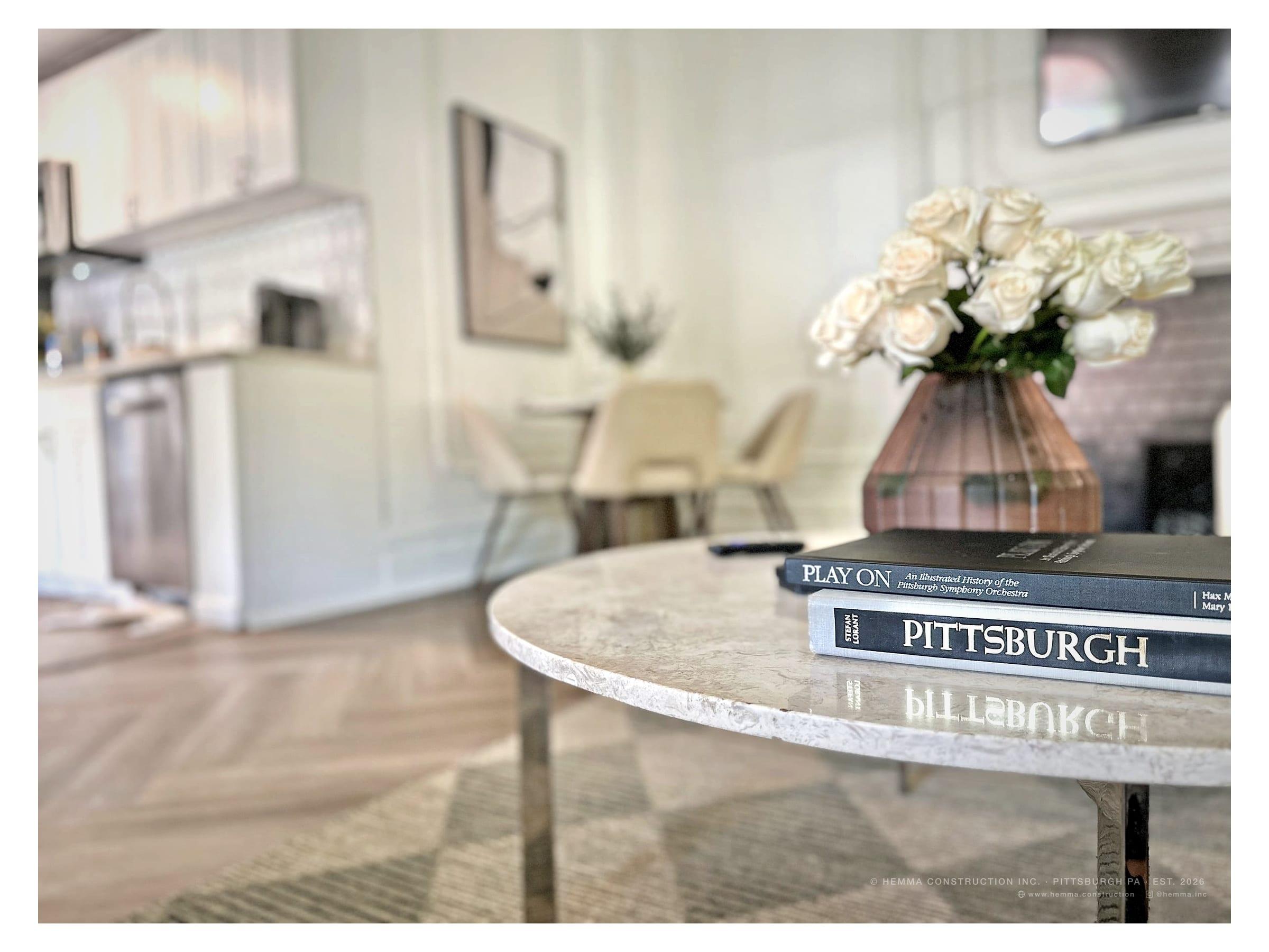 Coffee table detail — Pittsburgh books, roses, marble surface