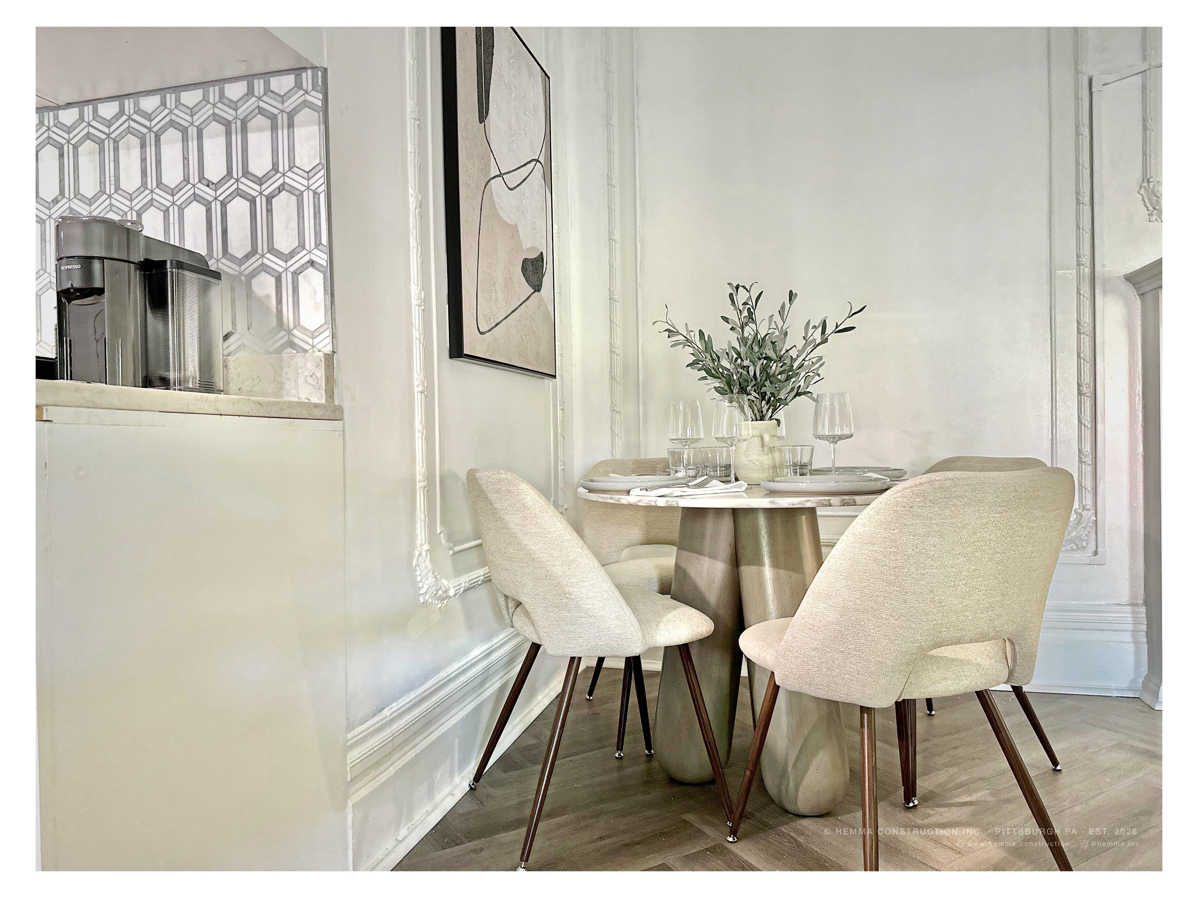 Dining area — marble table, linen chairs, abstract art