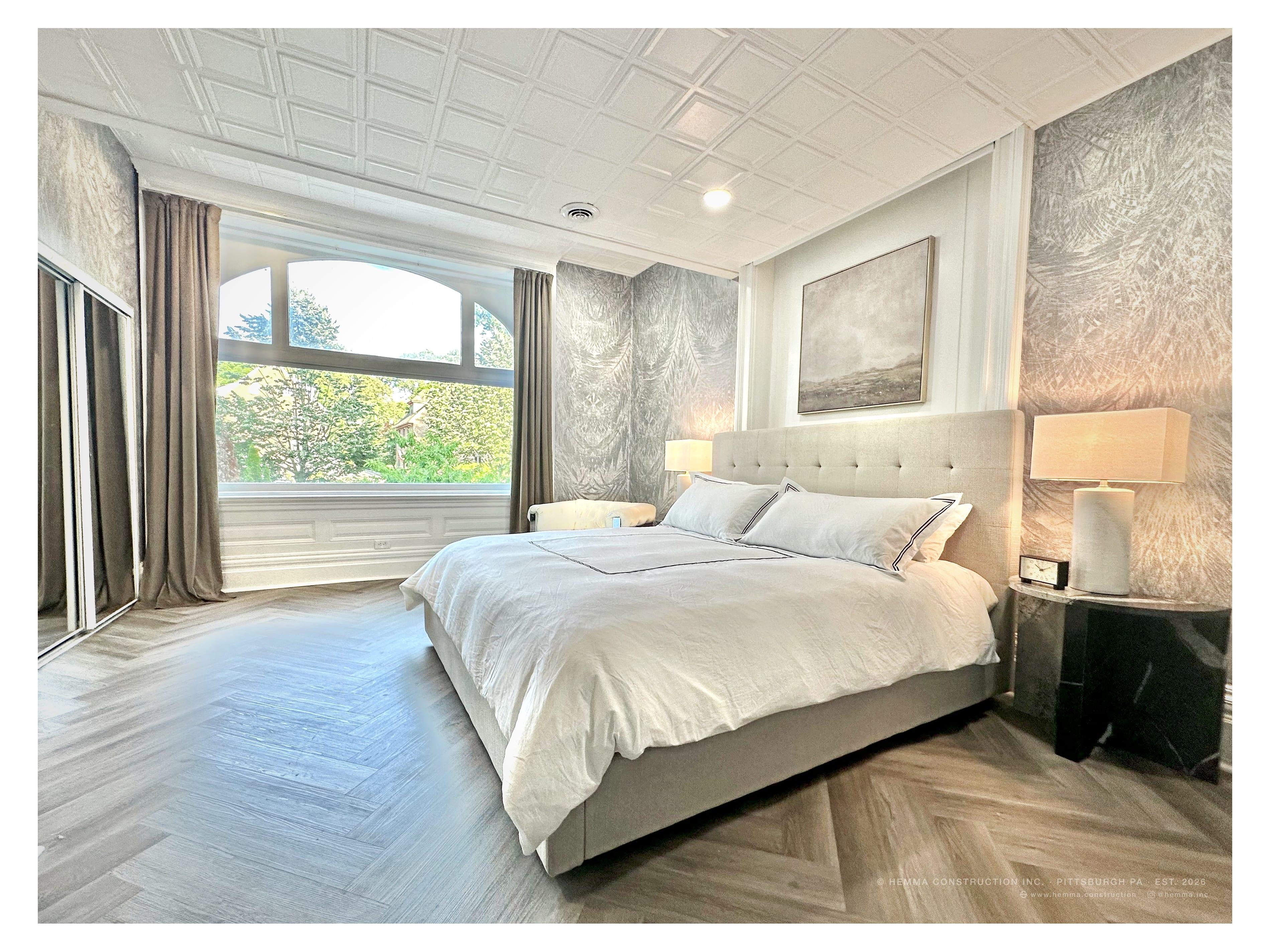 Primary bedroom — full room with arched window and patterned wallpaper