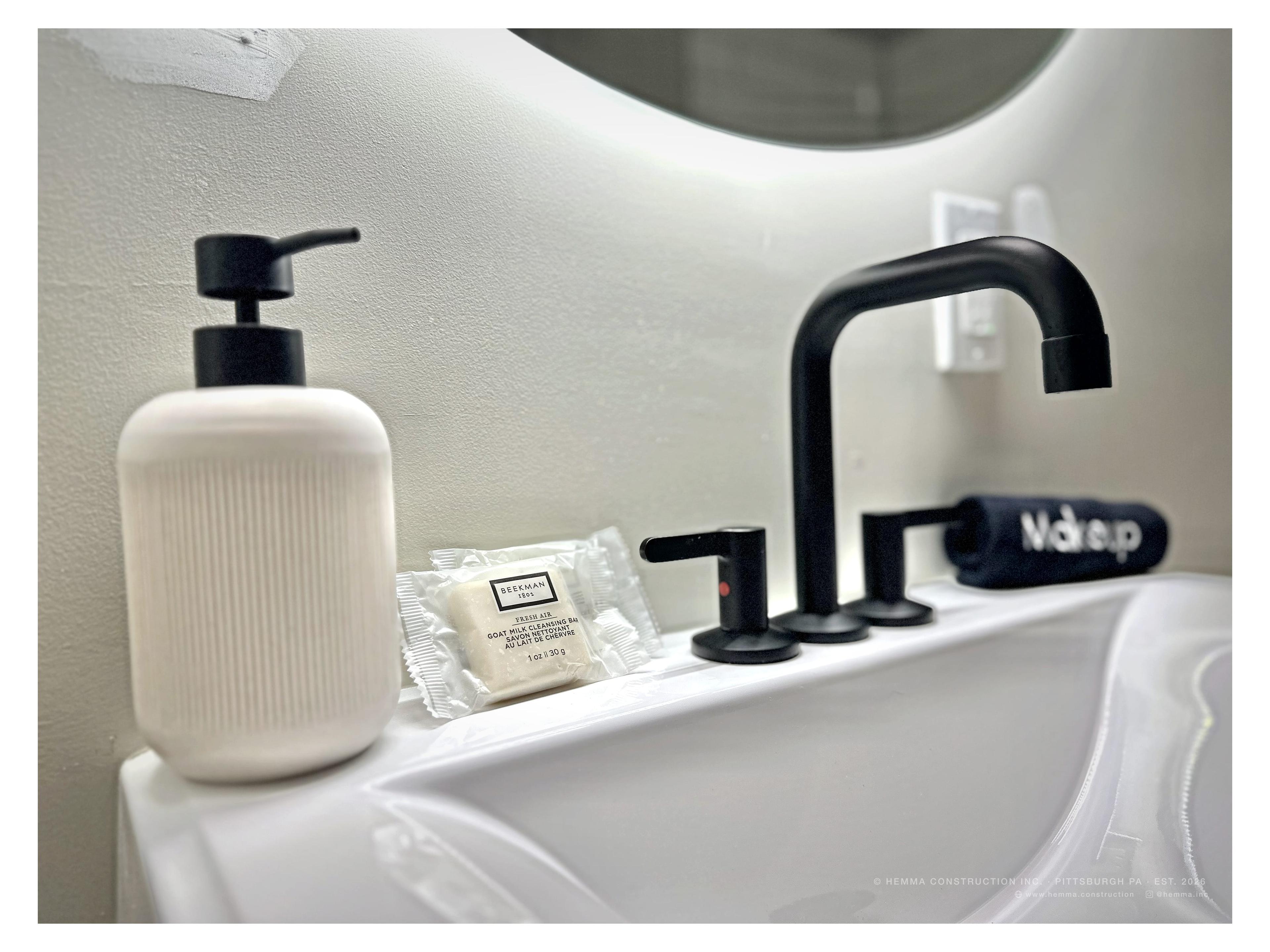 Bathroom vanity — Beekman amenities and matte black faucet