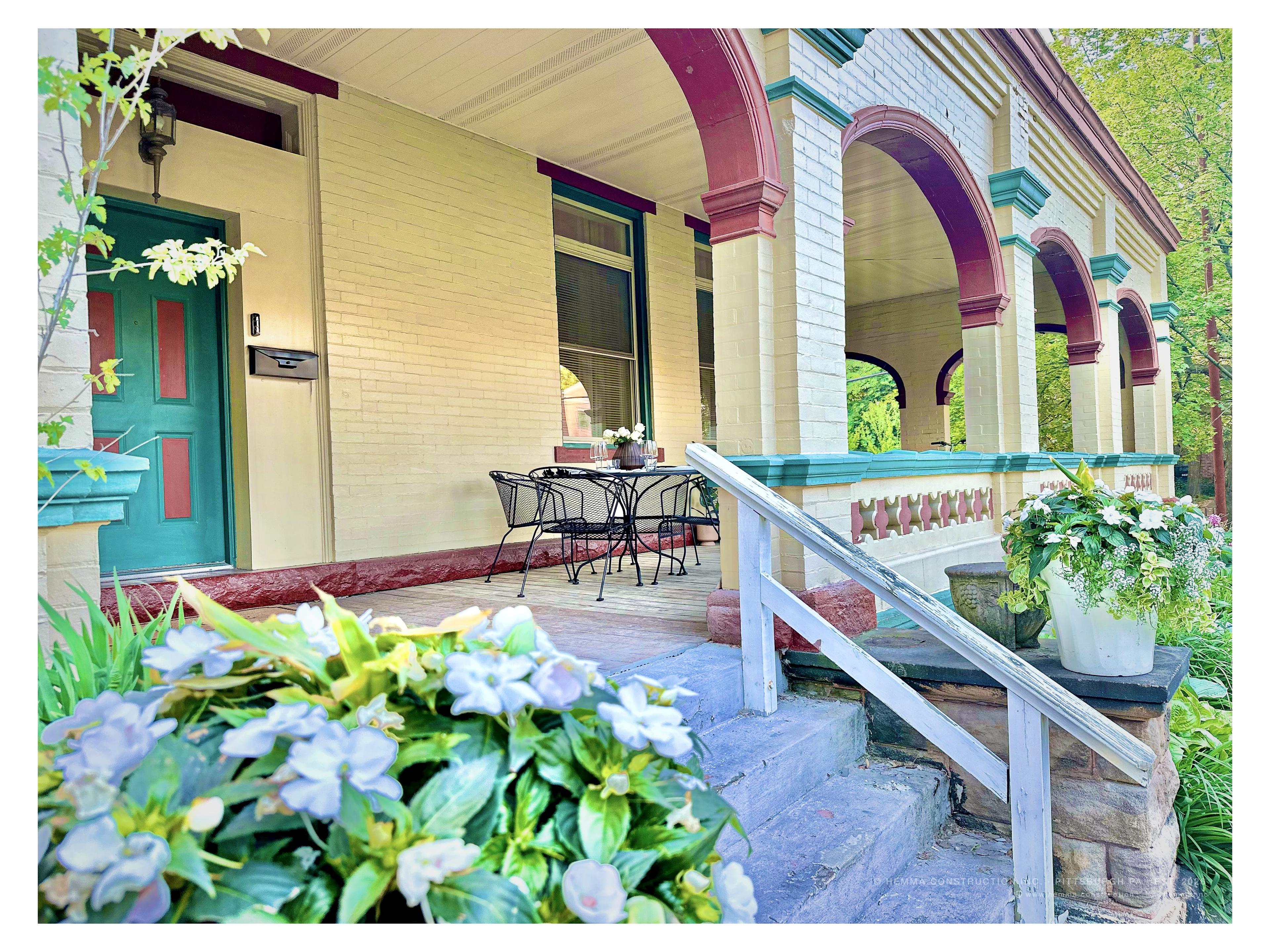 Front porch entry with Victorian arches and seasonal plantings