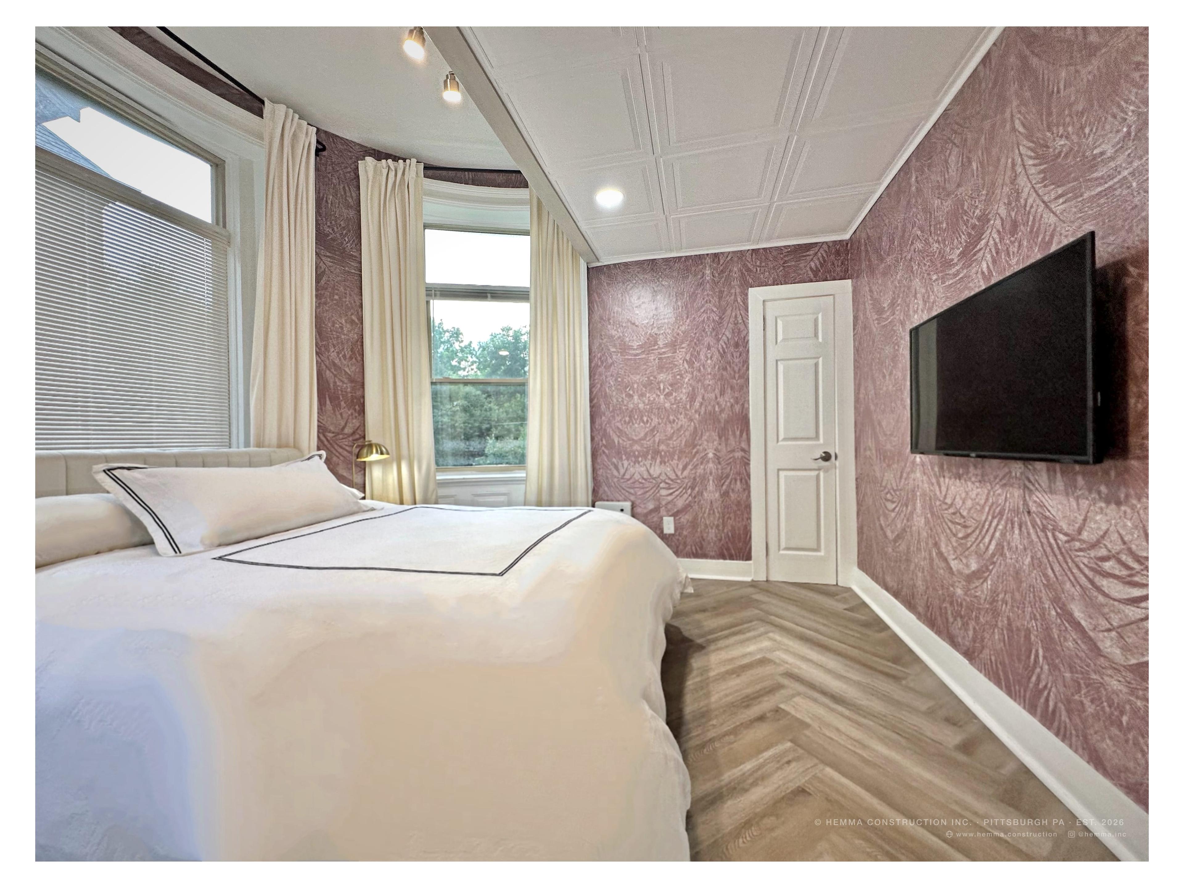 Unit 3 bedroom — pink botanical wallpaper, bay window, white hotel linen