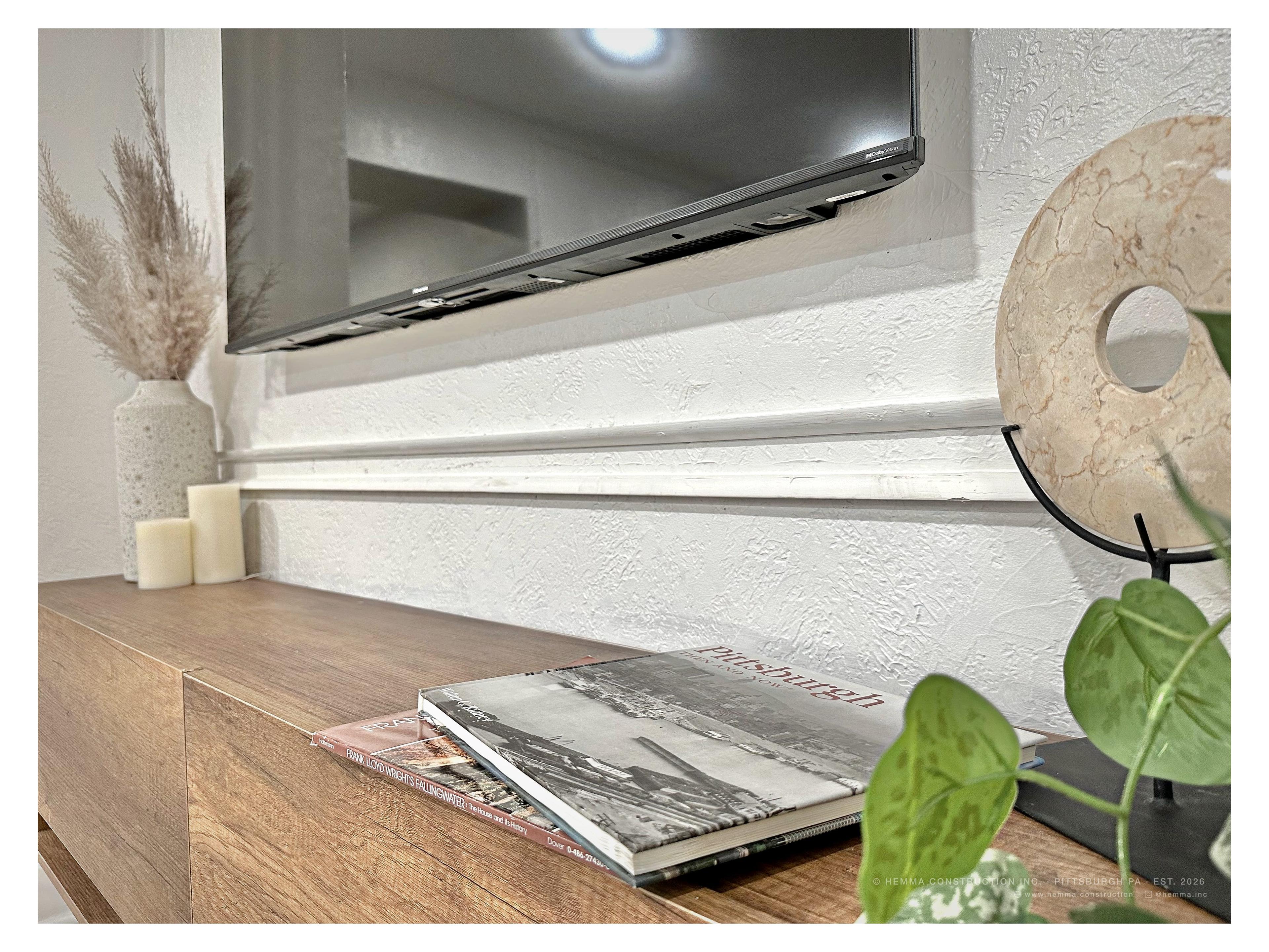 Living room credenza detail — Pittsburgh books, pampas grass, marble disc sculpture