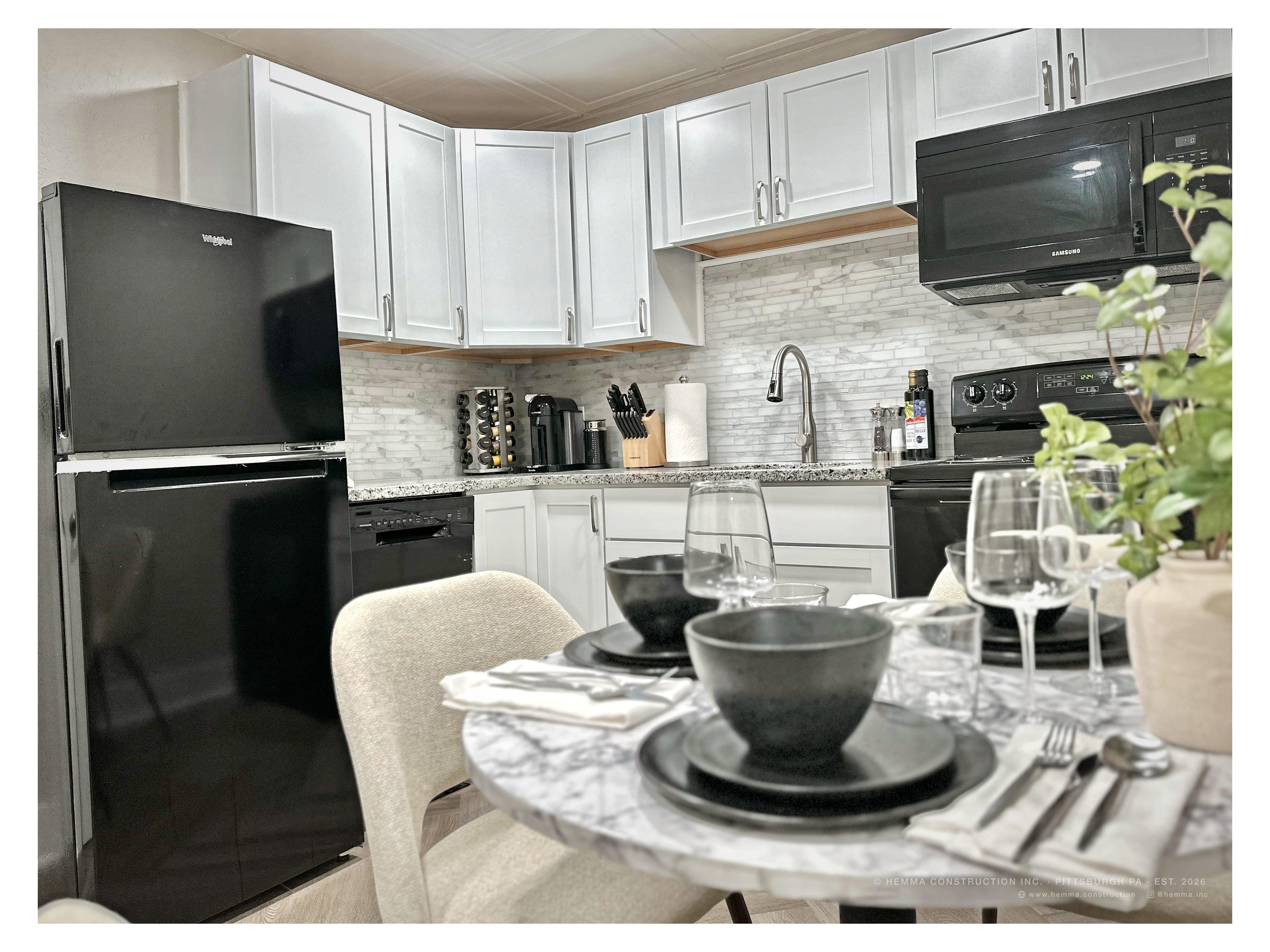 Kitchen — white cabinets, black appliances, marble backsplash, marble dining table set
