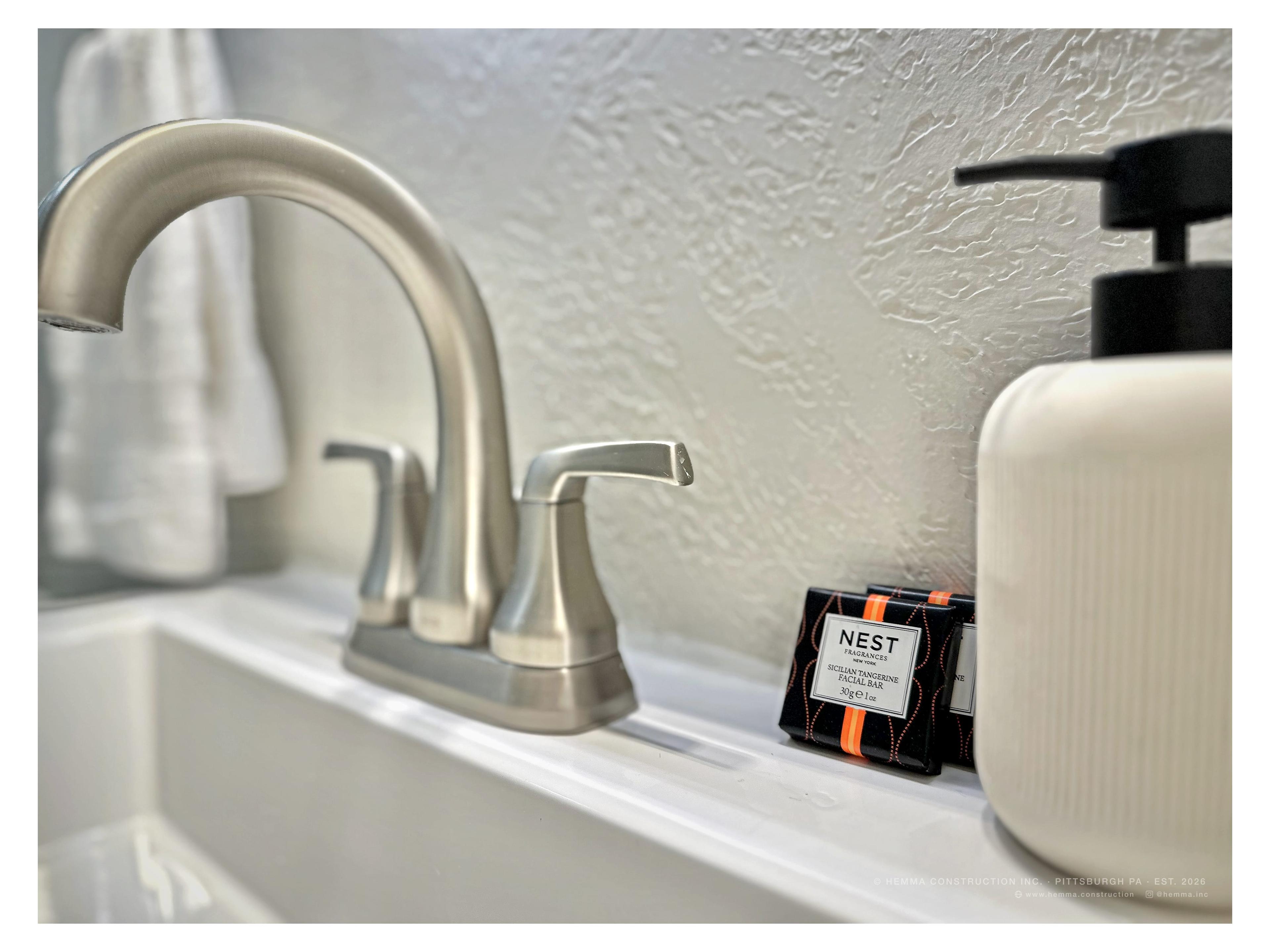 Bathroom vanity detail — brushed nickel faucet, Nest soaps