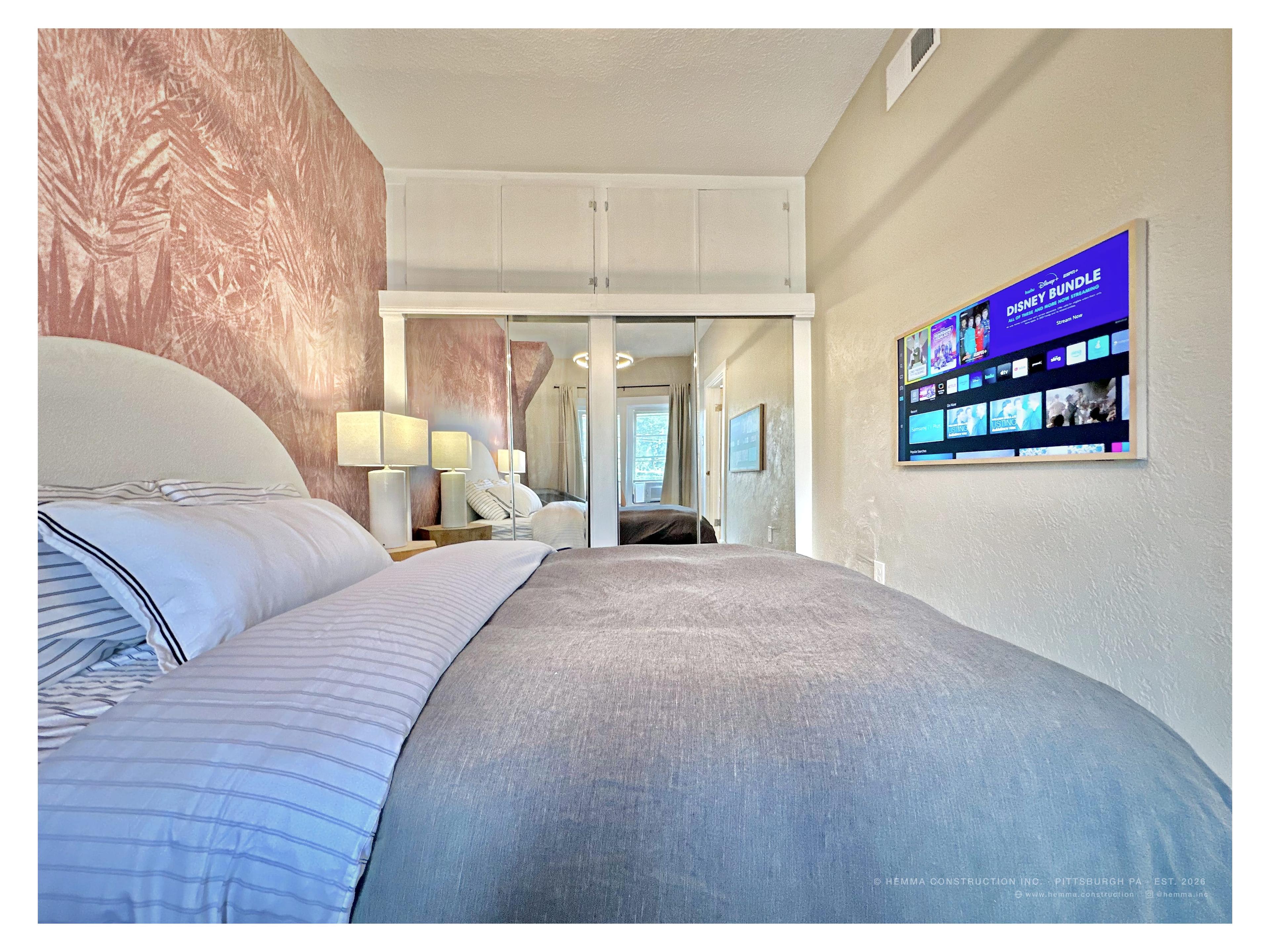 Bedroom full room — pink botanical wallpaper, mirrored wardrobe, arched headboard